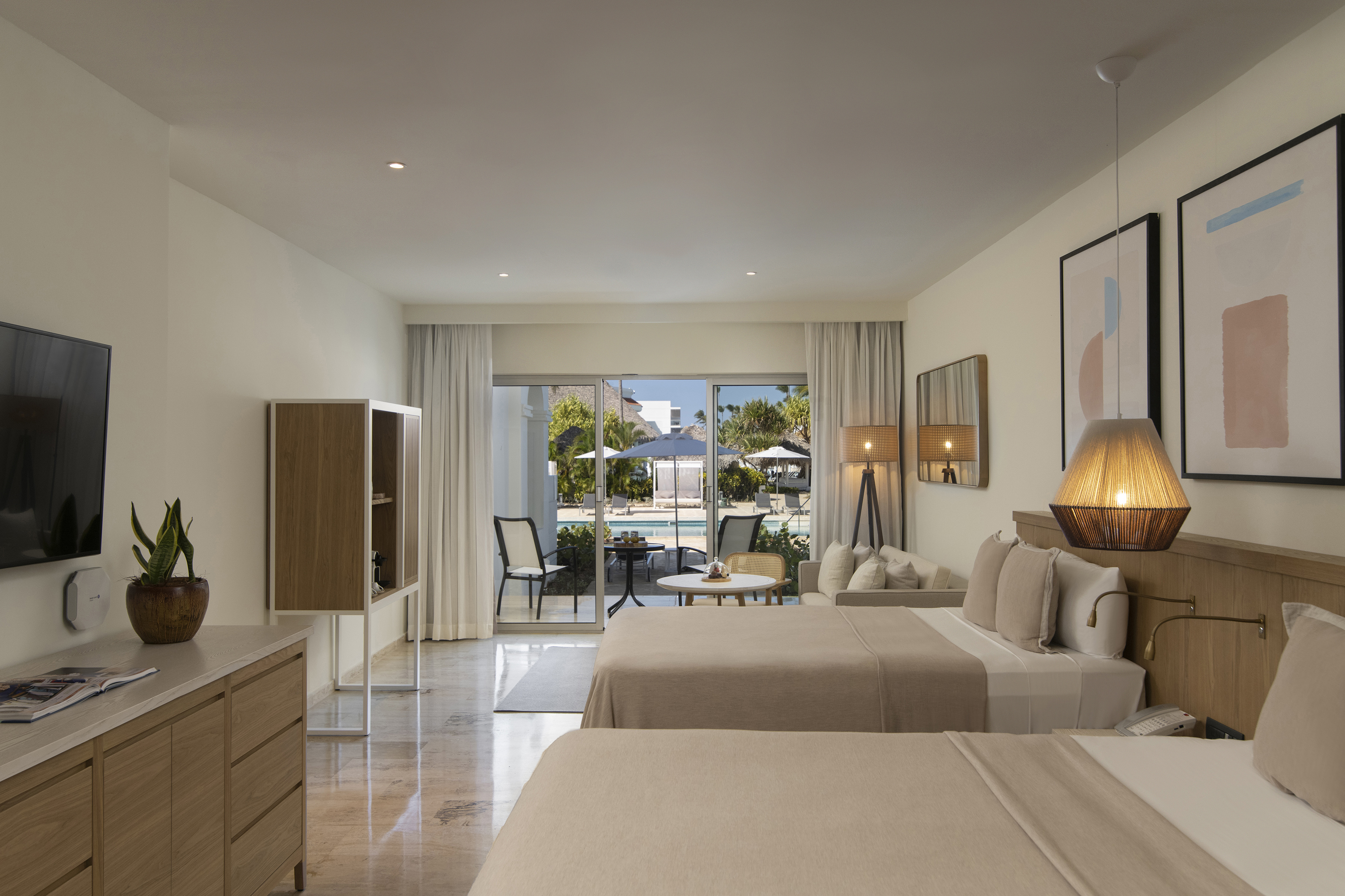 a room with two beds and a table and chairs