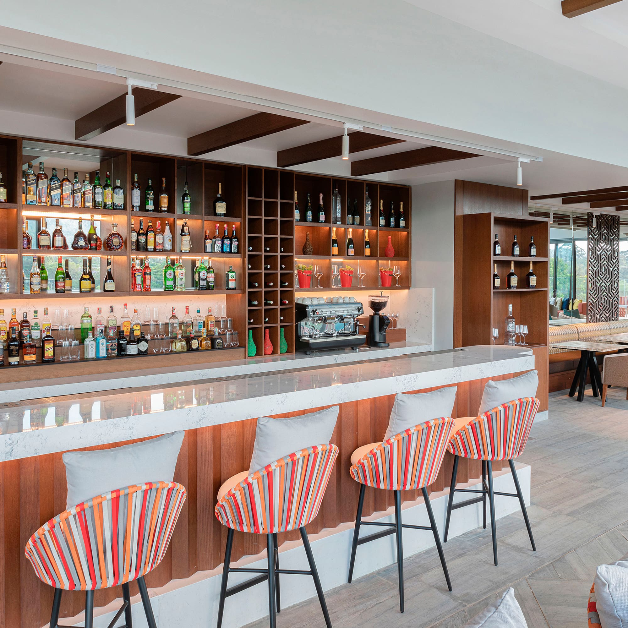 a bar with shelves of liquor and chairs