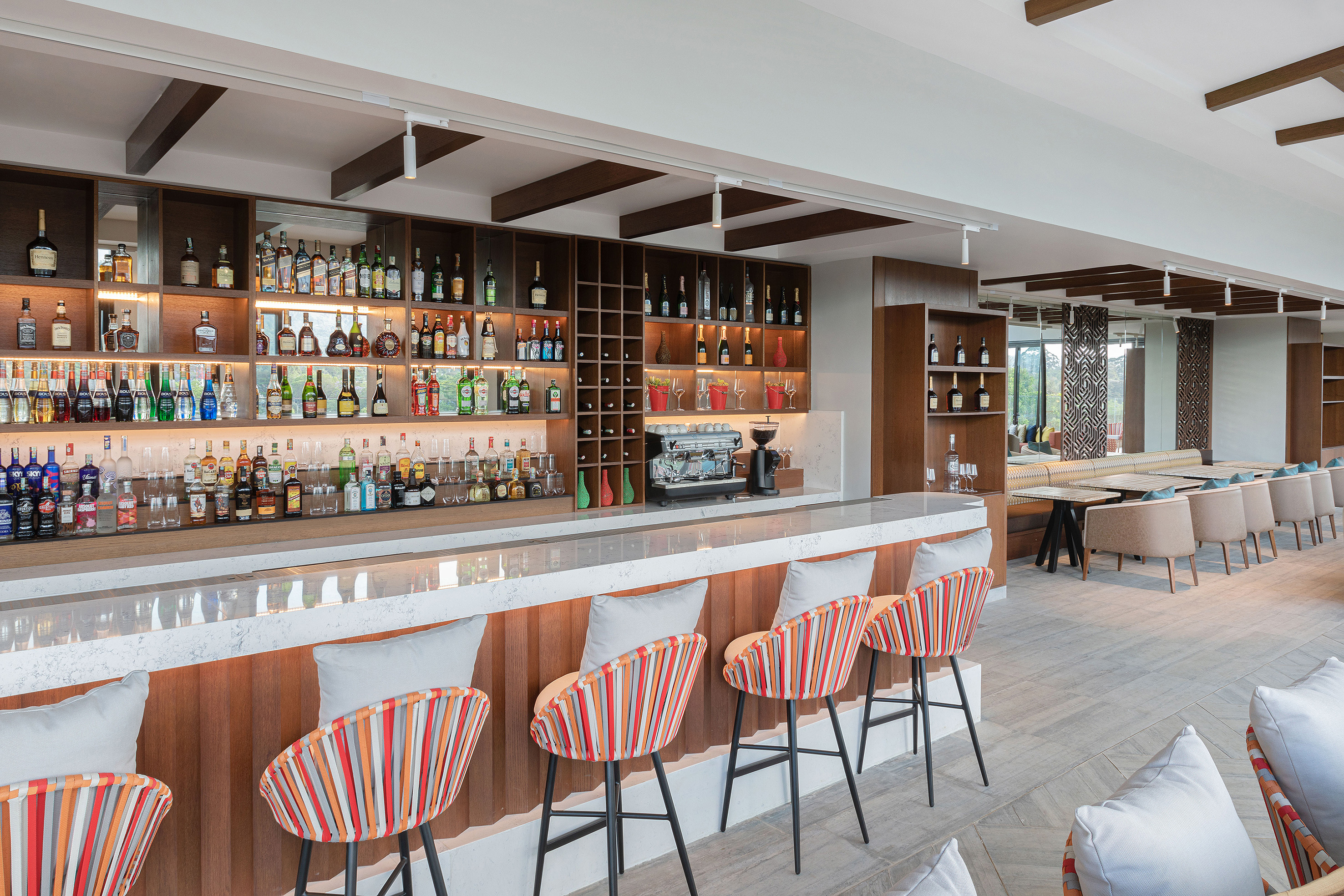 a bar with shelves of liquor and chairs