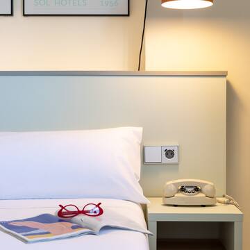 a bed with a telephone and a book on it