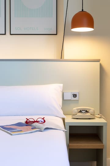 a bed with a telephone and a book on it