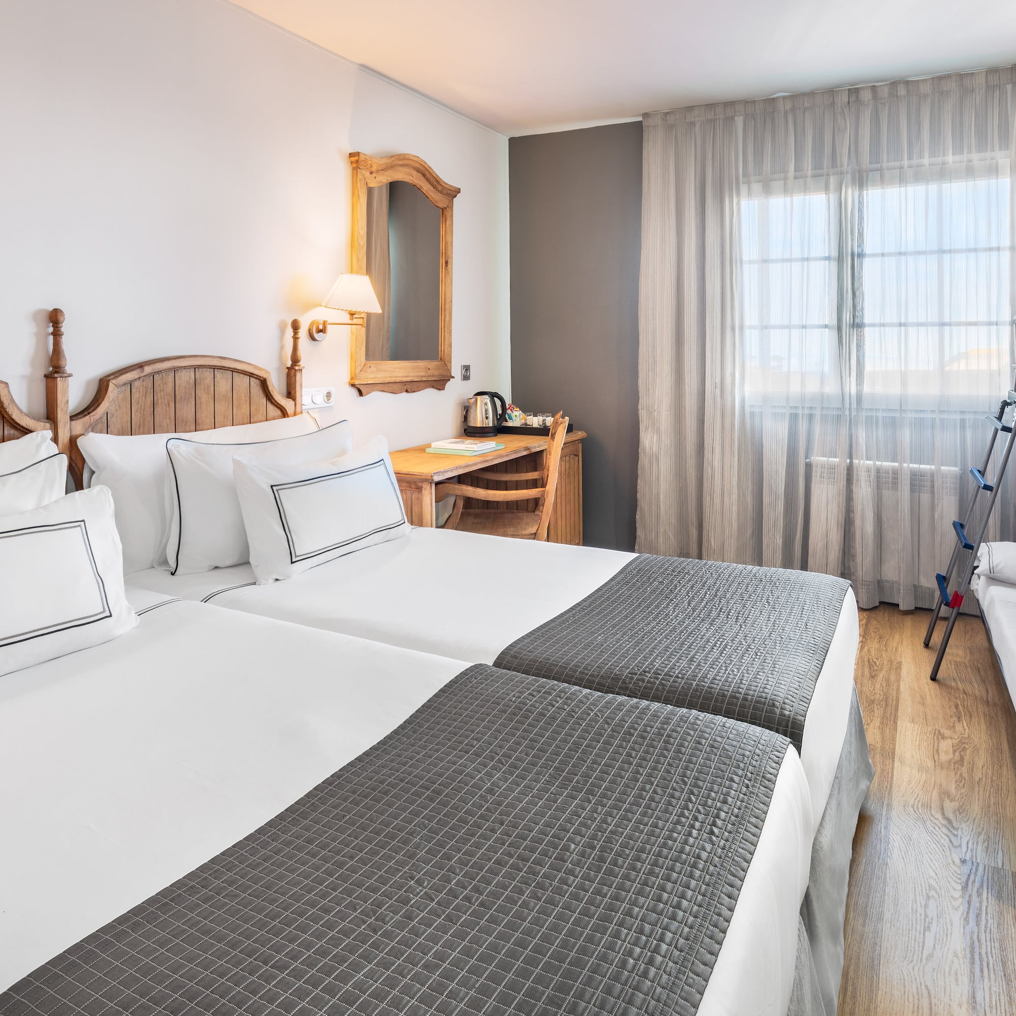 a room with two beds and a desk