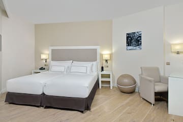 a room with a bed and chairs