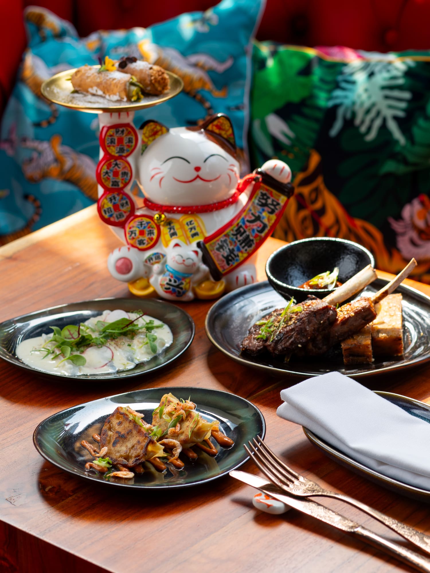 a table with plates of food and a cat statue