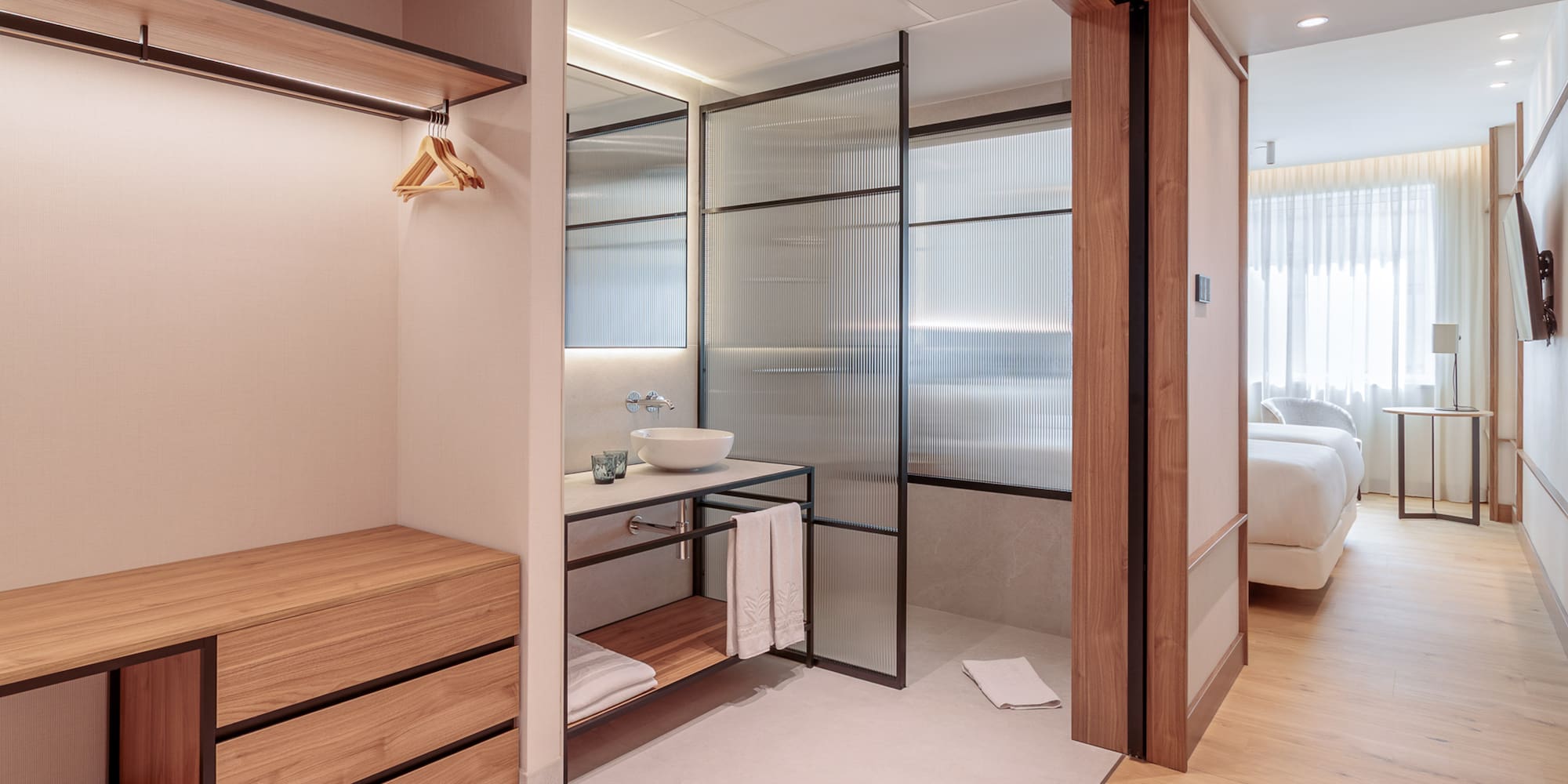 a bathroom with a wood cabinet and glass doors