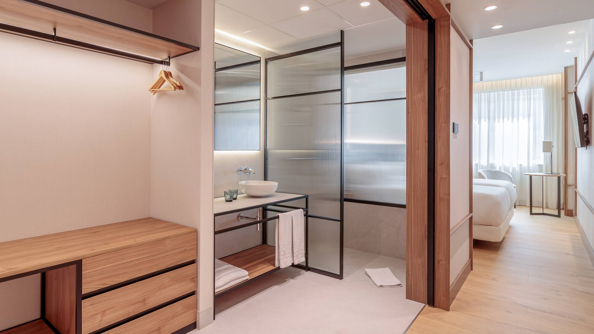 a bathroom with a wood cabinet and glass doors
