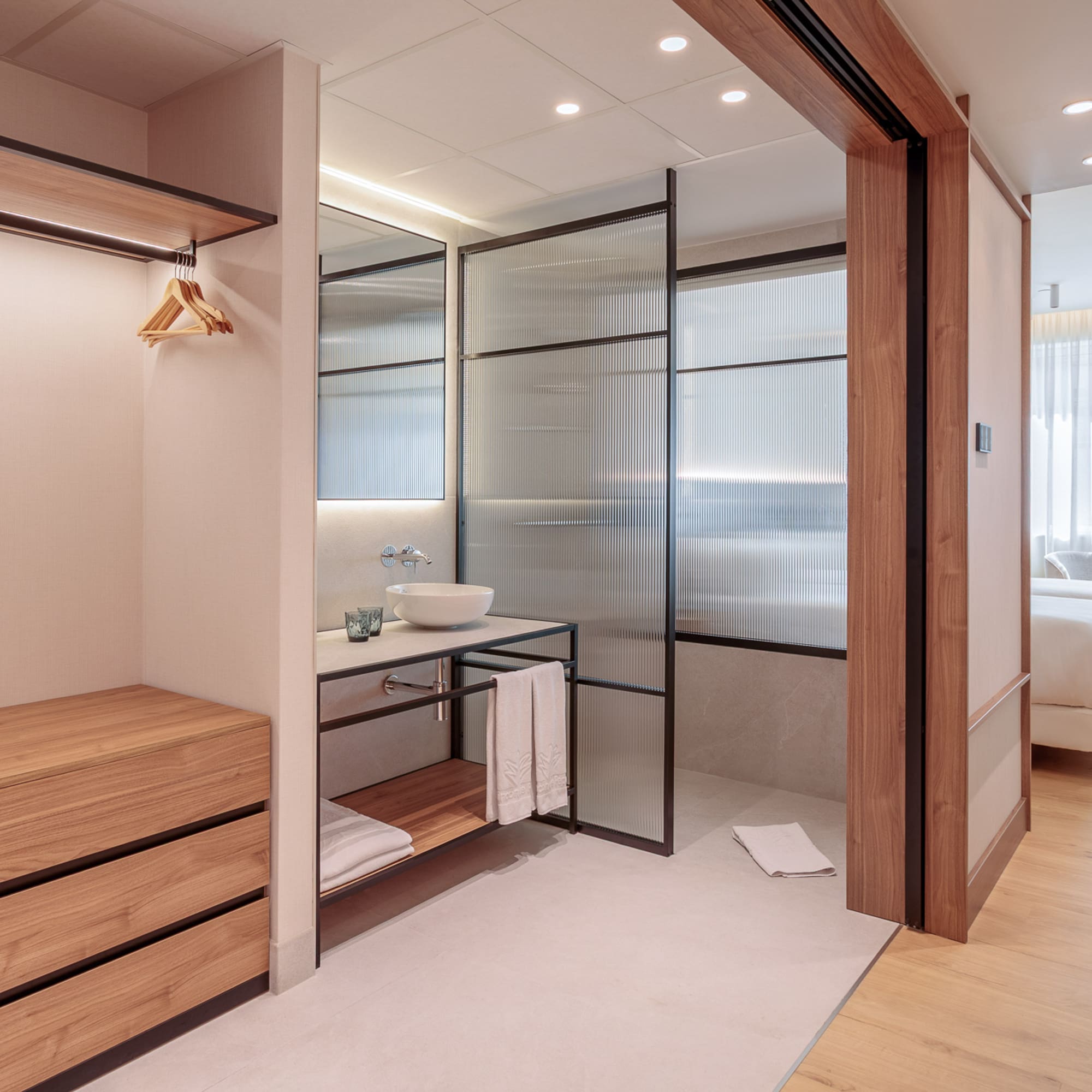 a bathroom with a wood cabinet and glass doors