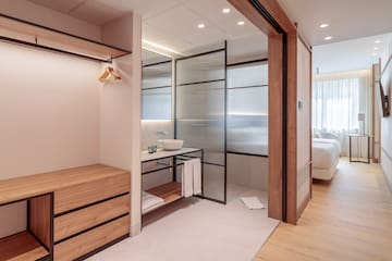 a bathroom with a wood cabinet and glass doors