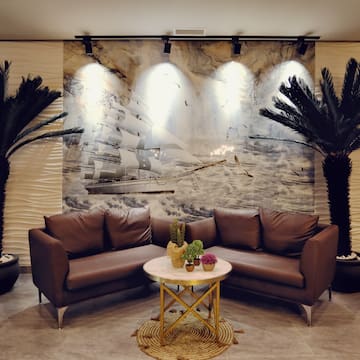 a room with couches and palm trees