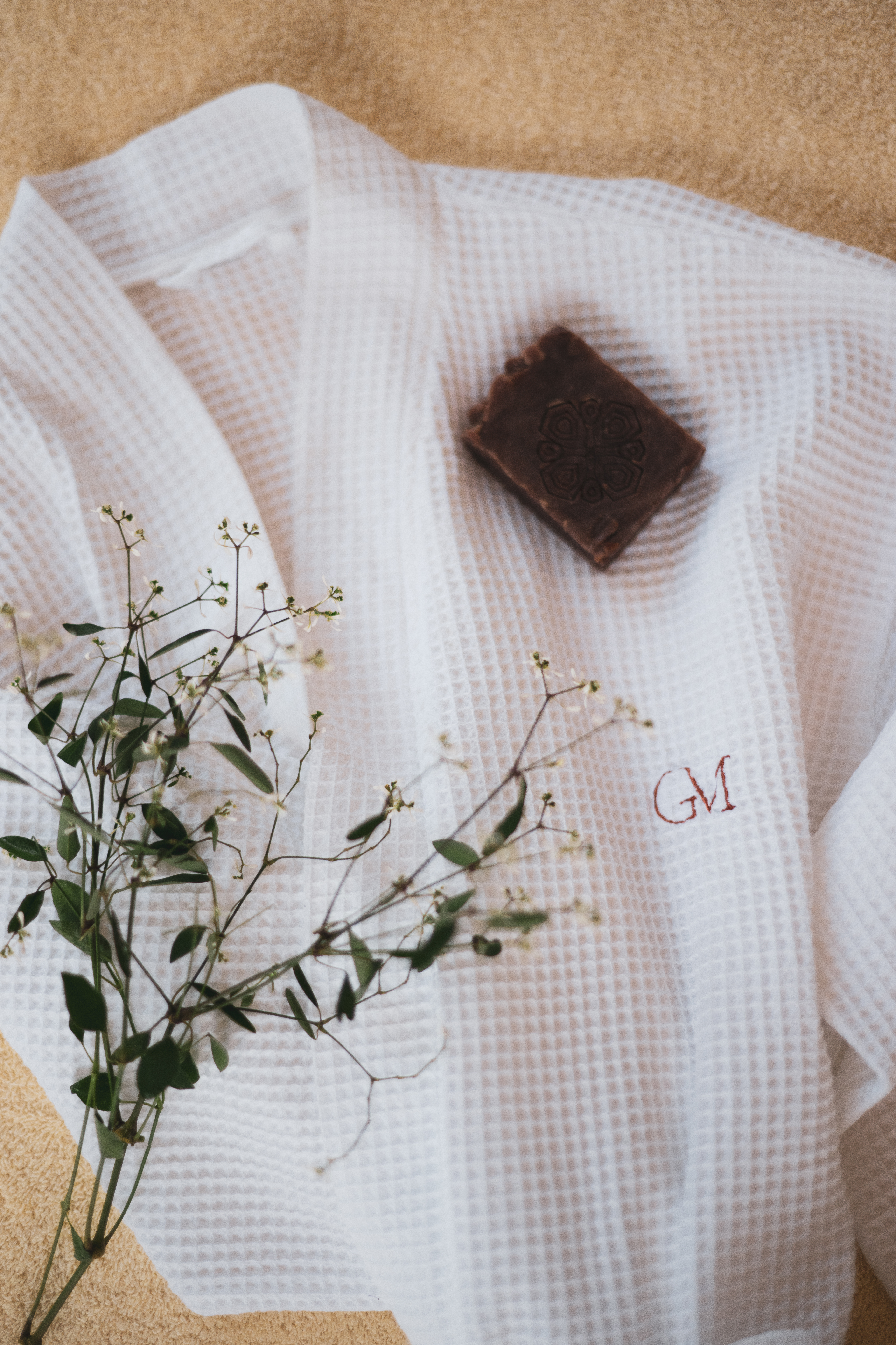 Spa essentials: white waffle bathrobe, GM embroidered initials, natural soap.