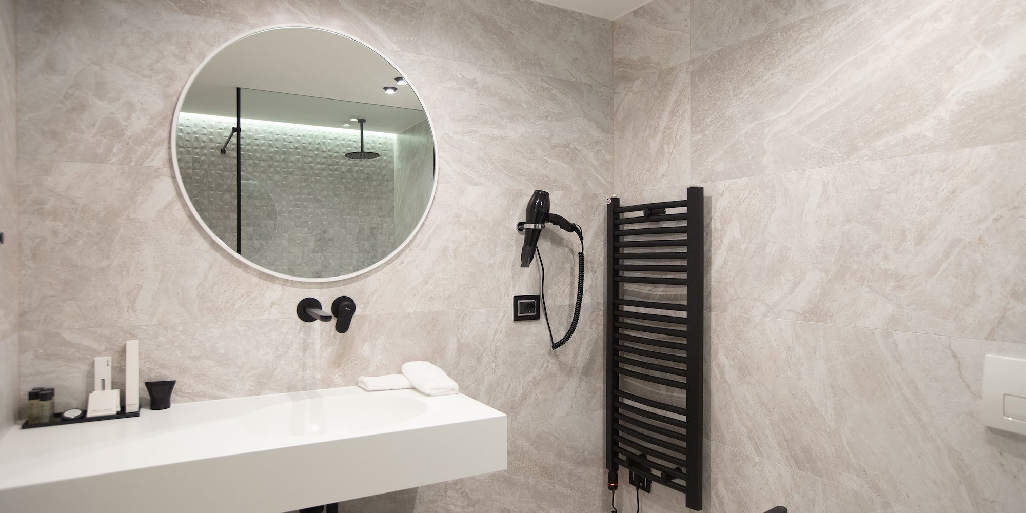 a bathroom with a round mirror and a sink