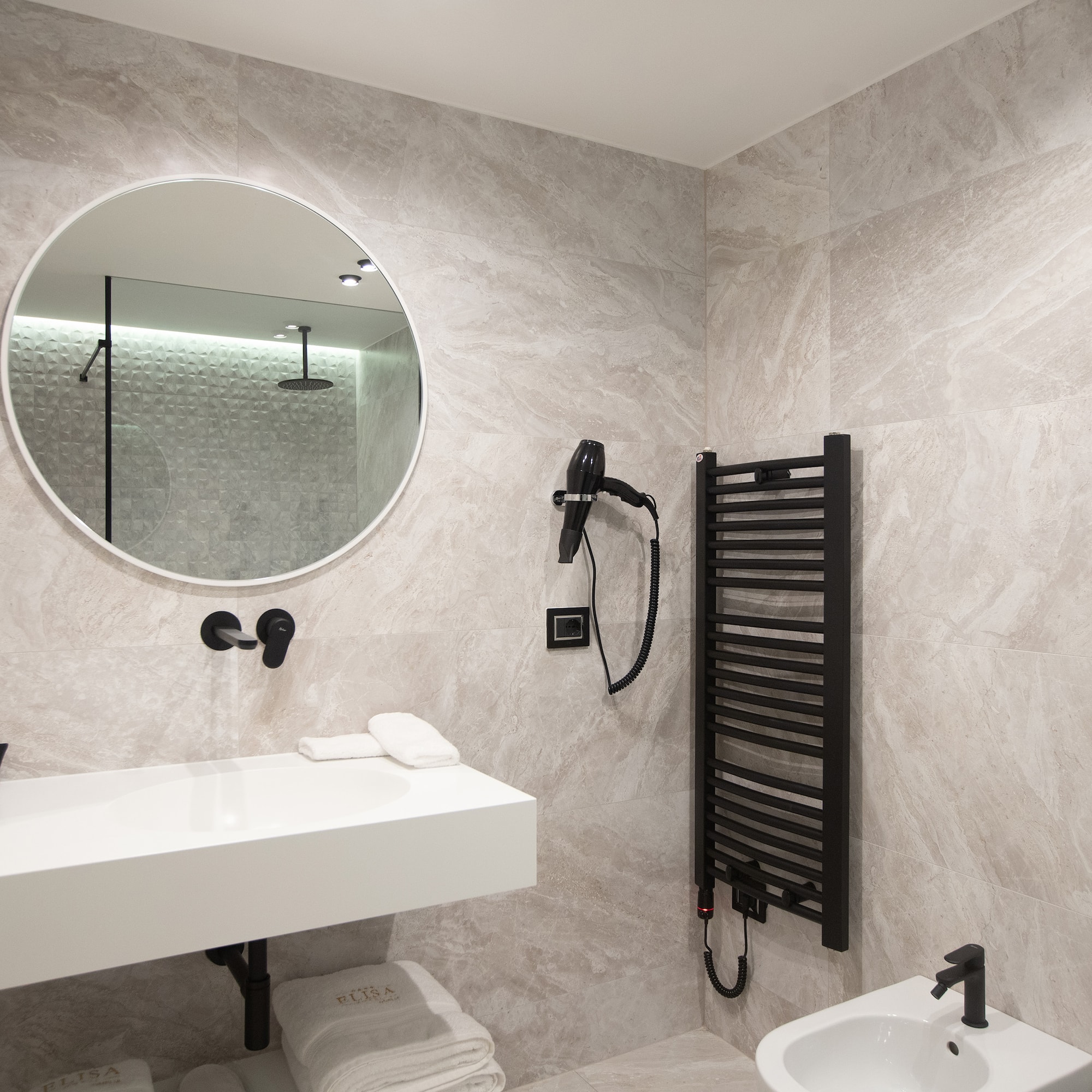 a bathroom with a round mirror and a sink