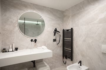 a bathroom with a round mirror and a sink