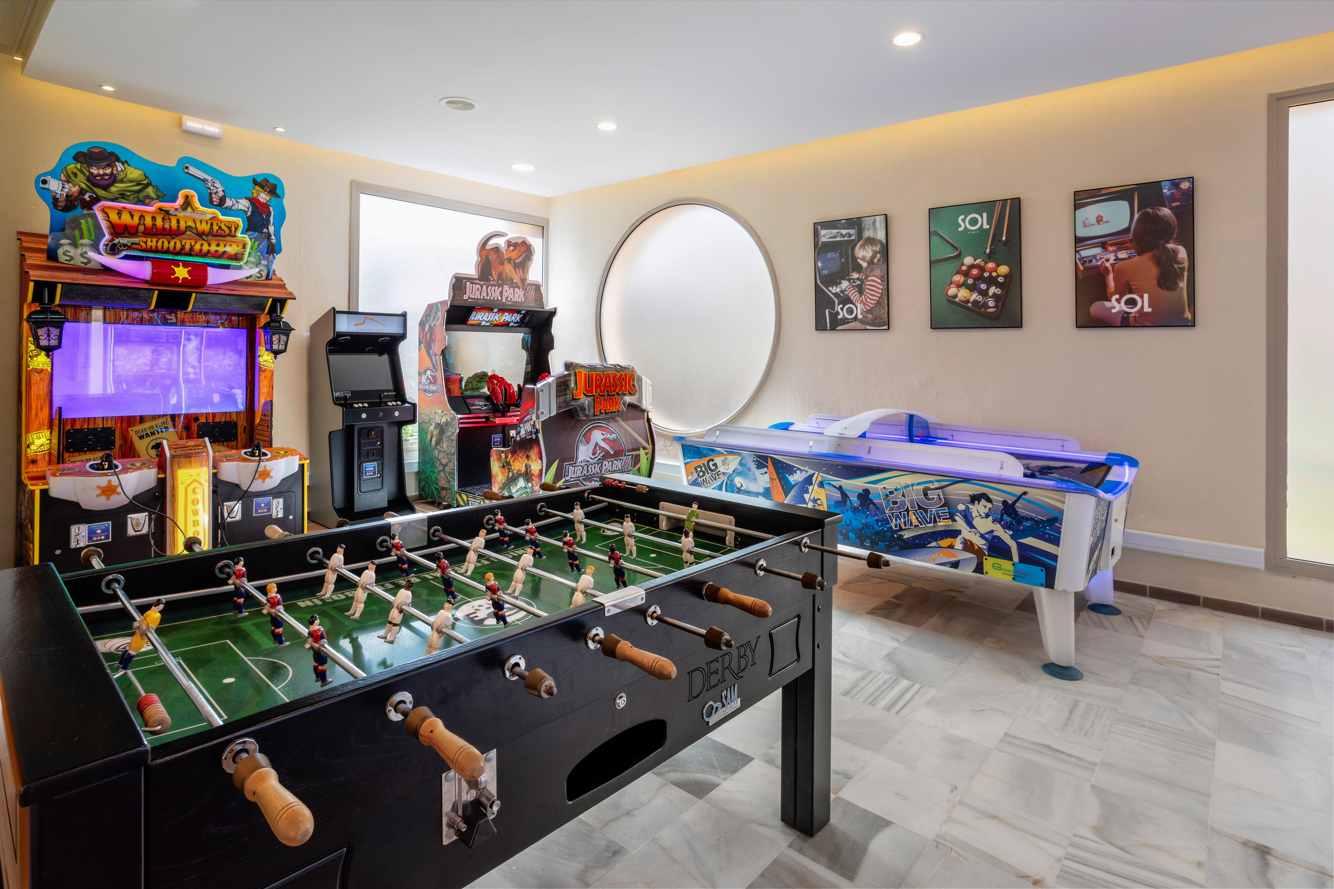 Game room with arcade machines, foosball table, and air hockey.
