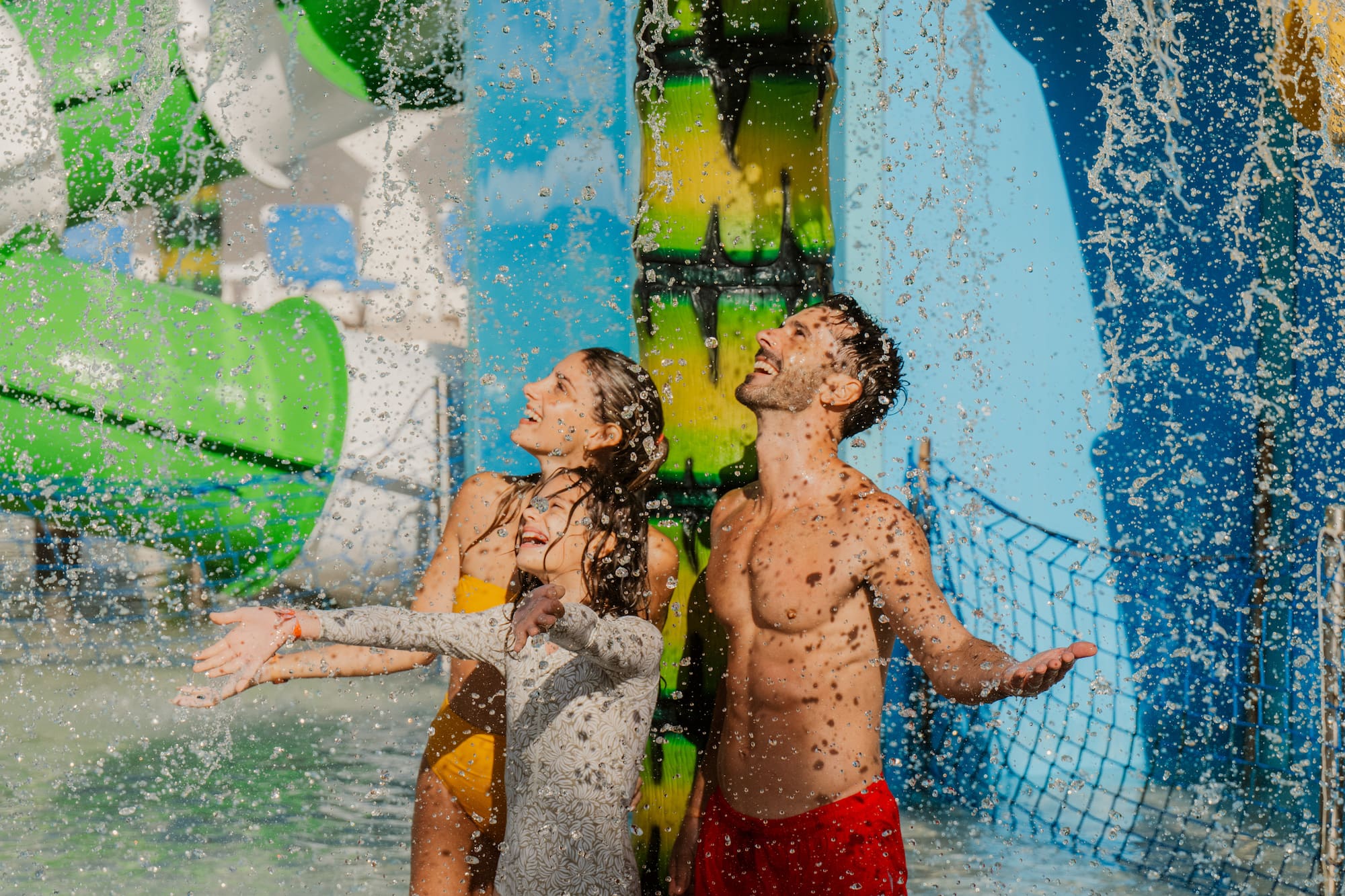 a man and woman in swimsuits under water slide