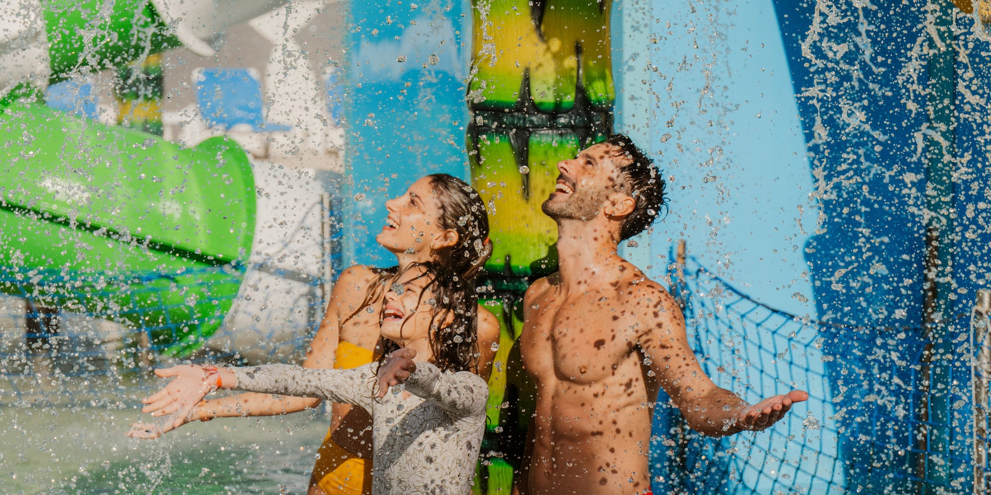 a man and woman in swimsuits under water slide