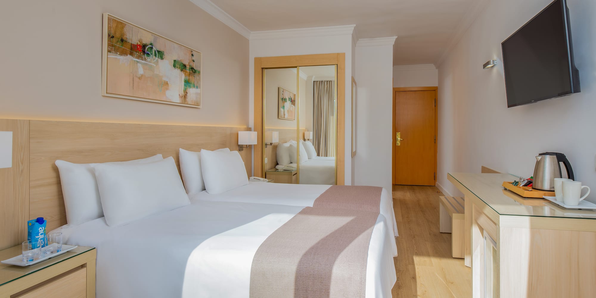 a room with two beds and a mirror