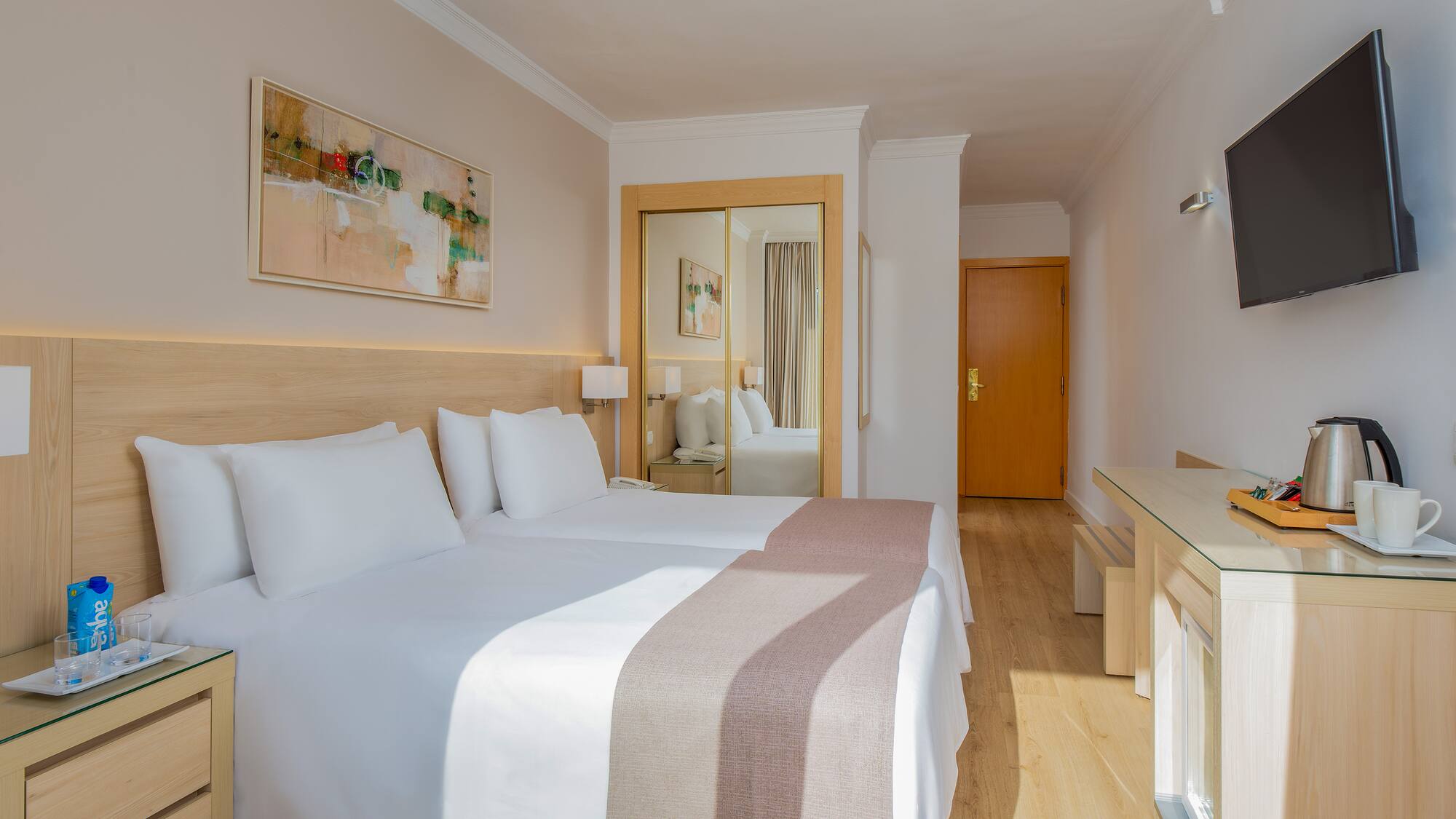 a room with two beds and a mirror