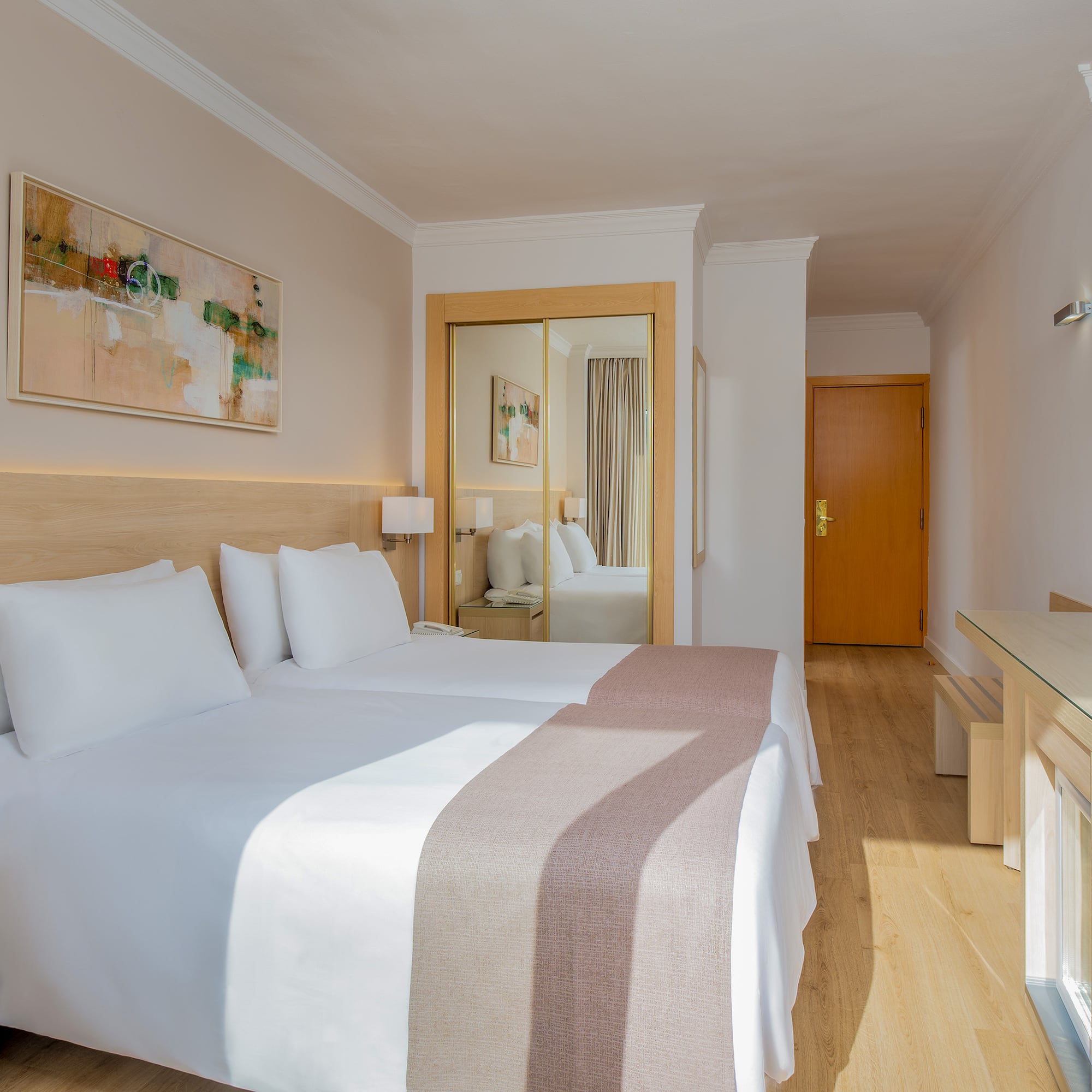 a room with two beds and a mirror