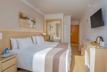 a room with two beds and a mirror