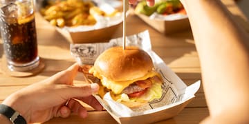 a person holding a burger