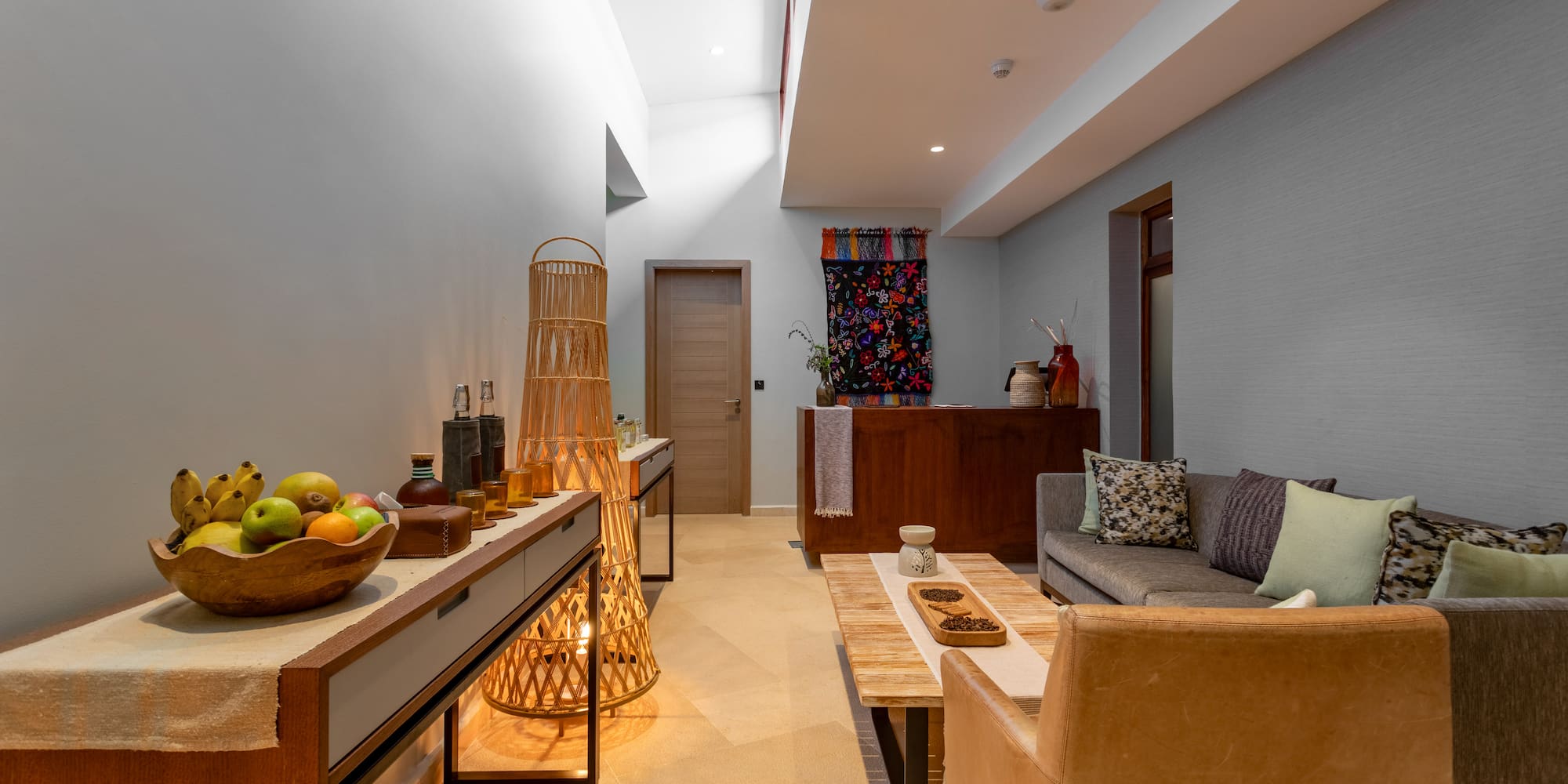 a room with a couch and a table with fruit on it