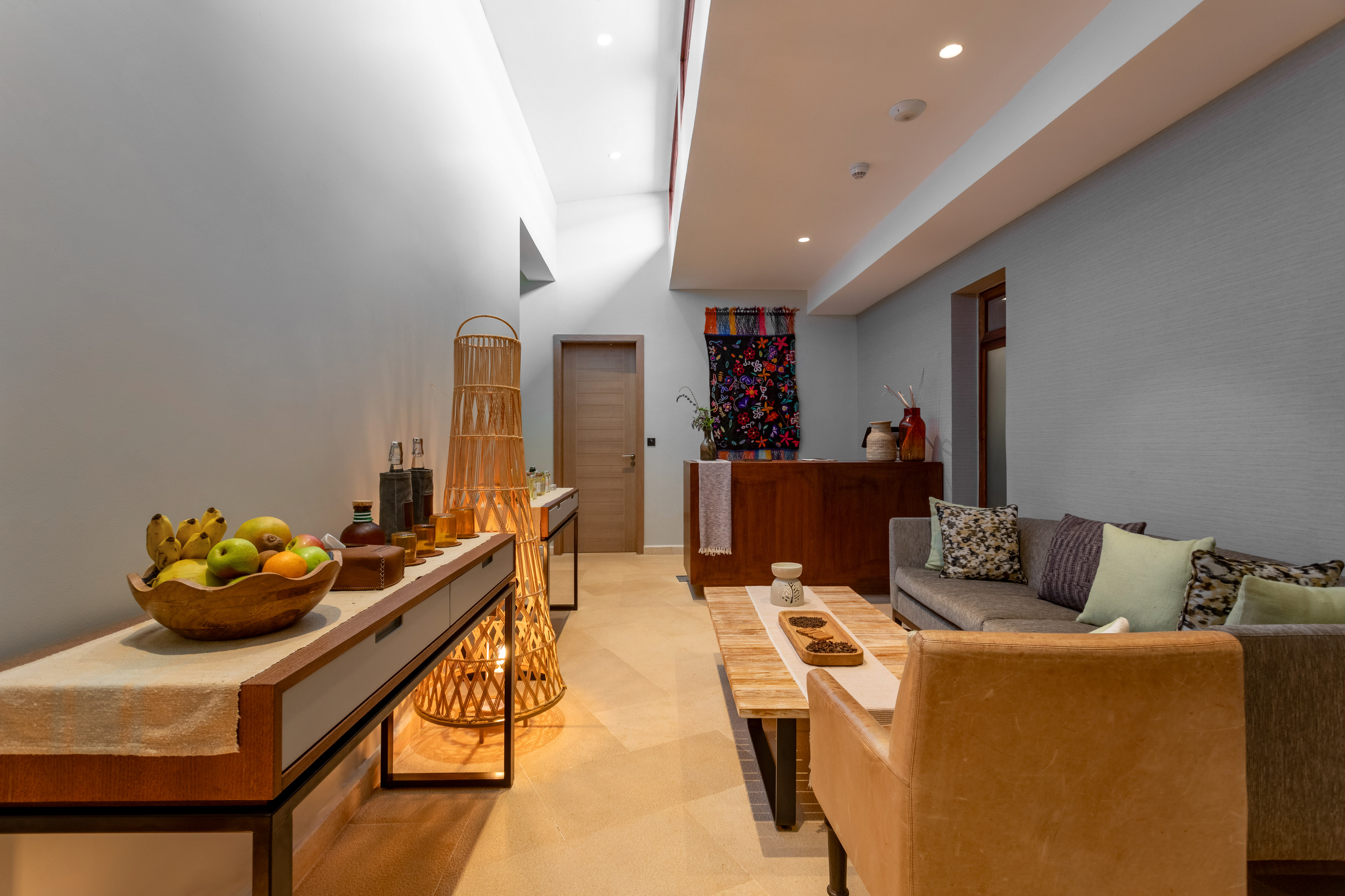 a room with a couch and a table with fruit on it