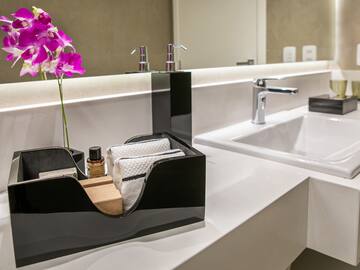 a black and white bathroom sink with a flower in a black box