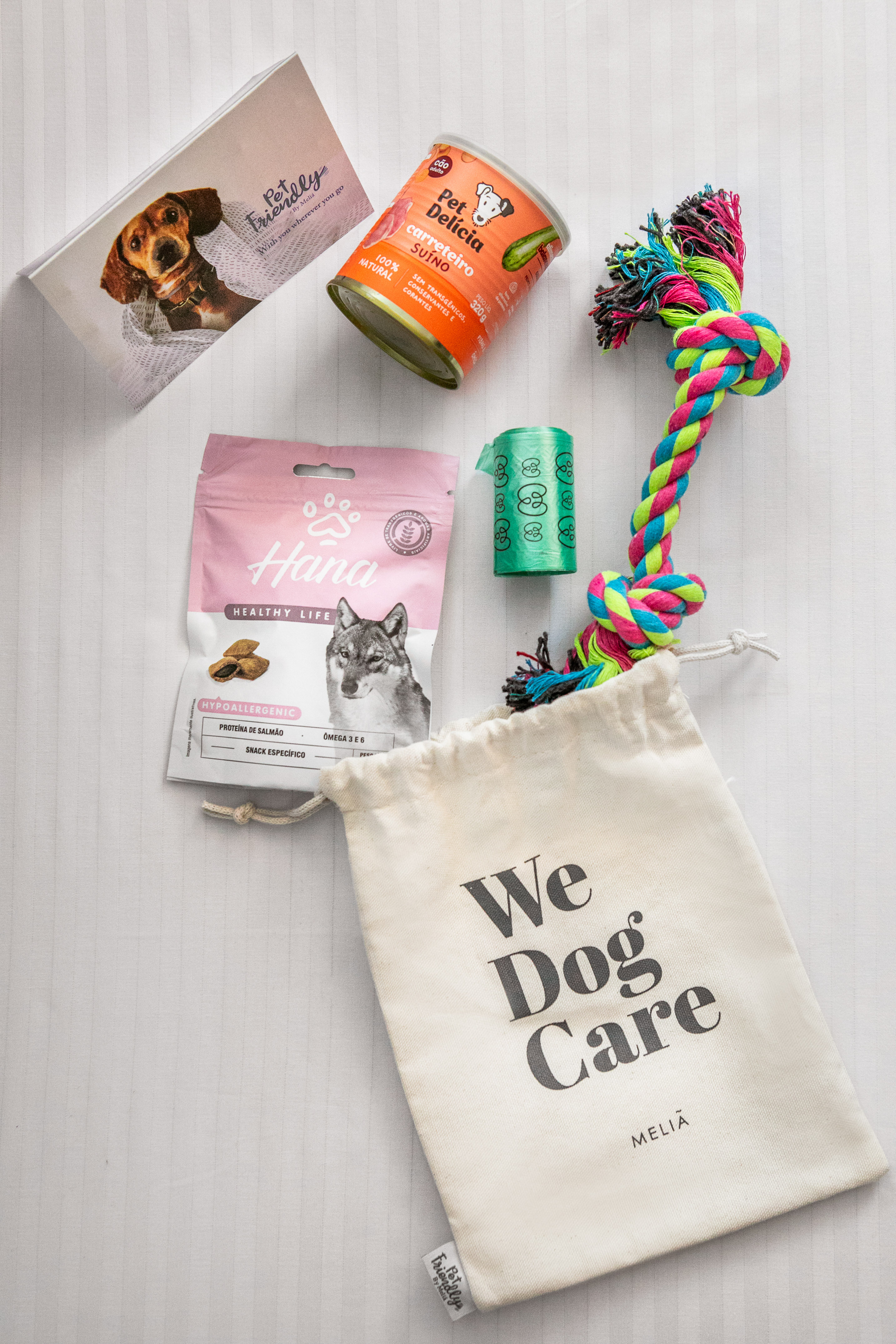 Meliã pet-friendly dog care package with food, colorful rope toy, and poop bags.