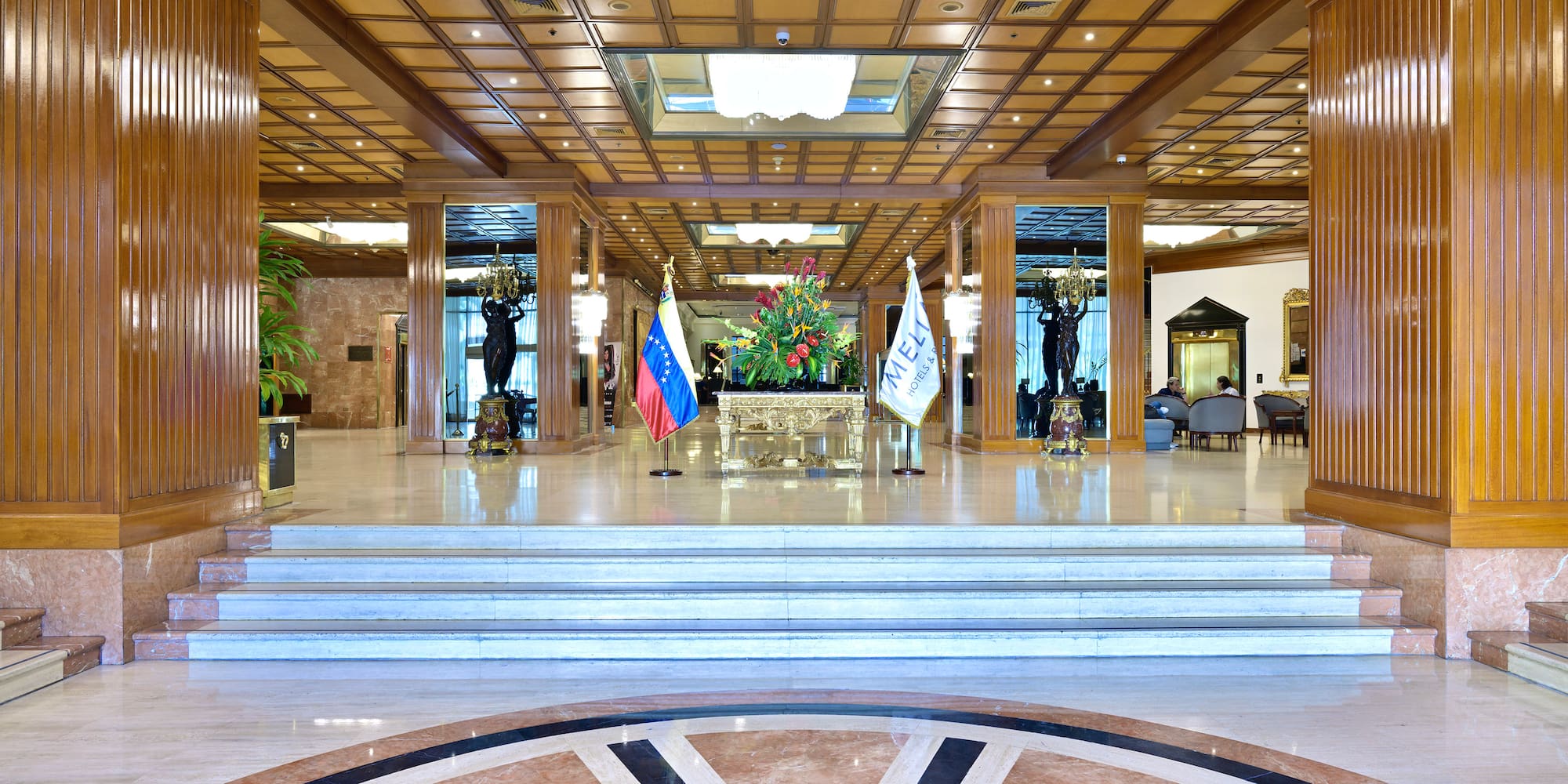 a large lobby with a staircase and flags