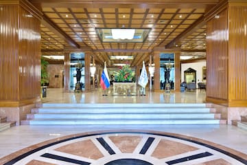 a large lobby with a staircase and flags