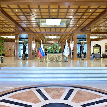 a large lobby with a staircase and flags