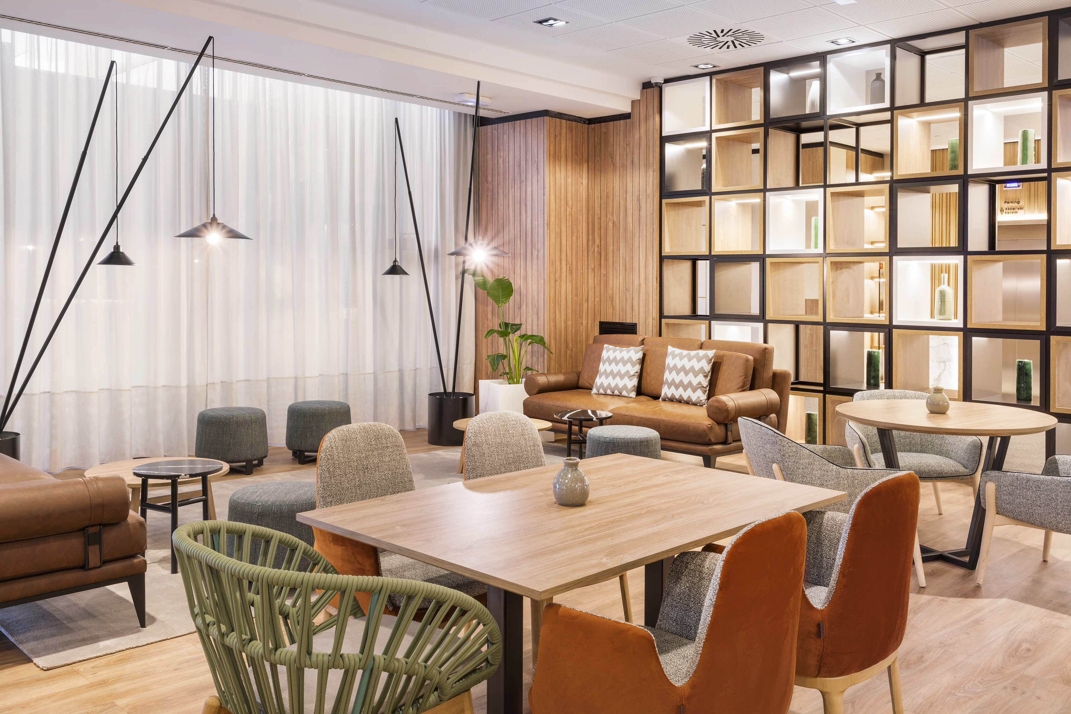 Modern hotel lobby lounge with comfortable seating and wood design.