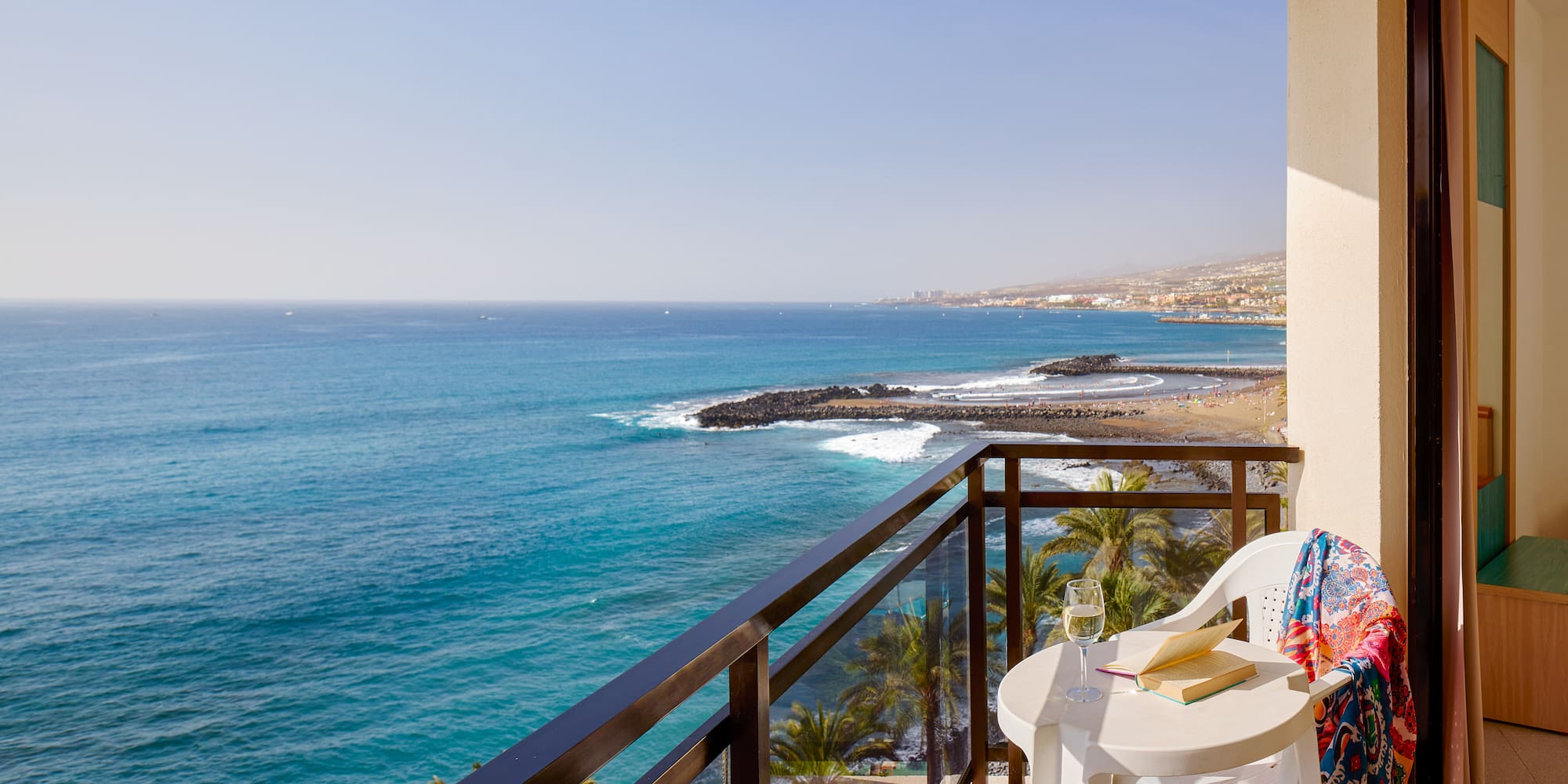 a balcony with a table and chairs overlooking the ocean