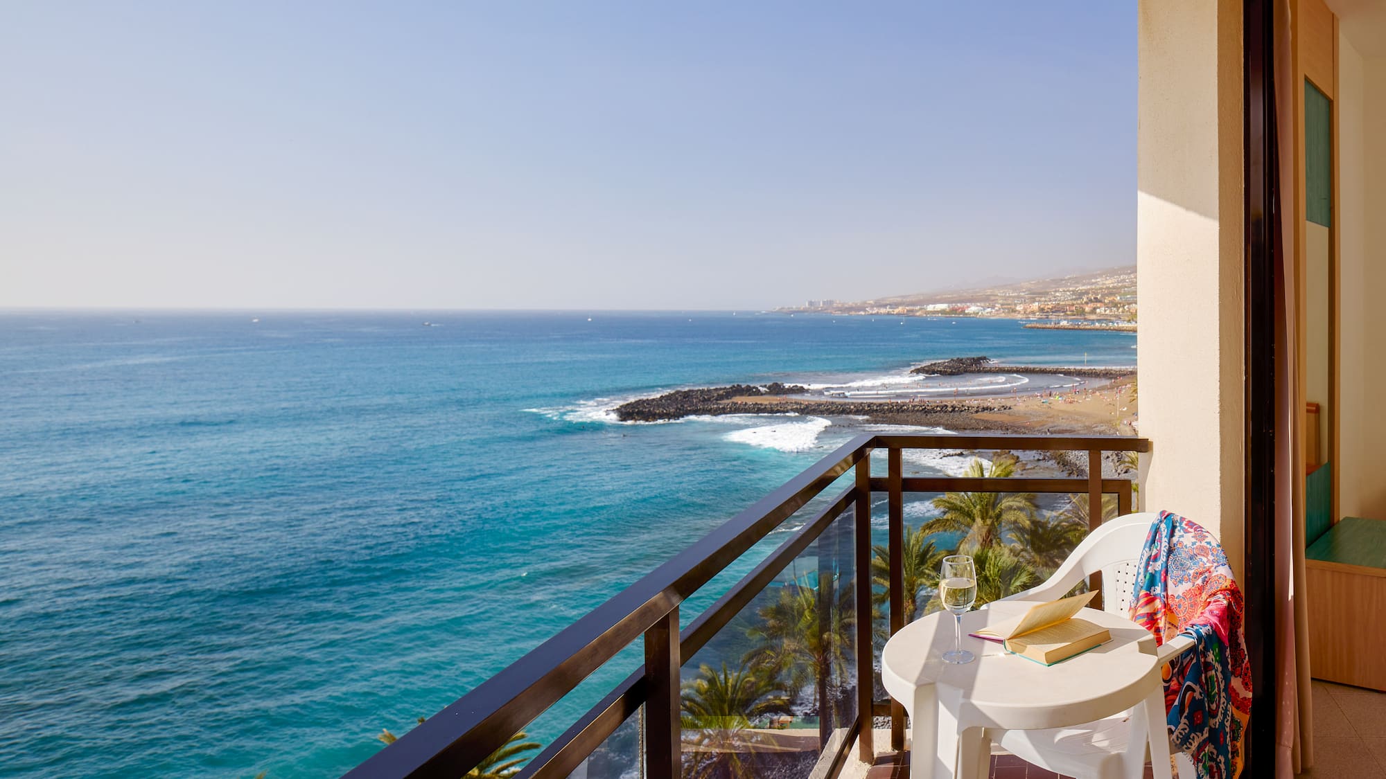 a balcony with a table and chairs overlooking the ocean
