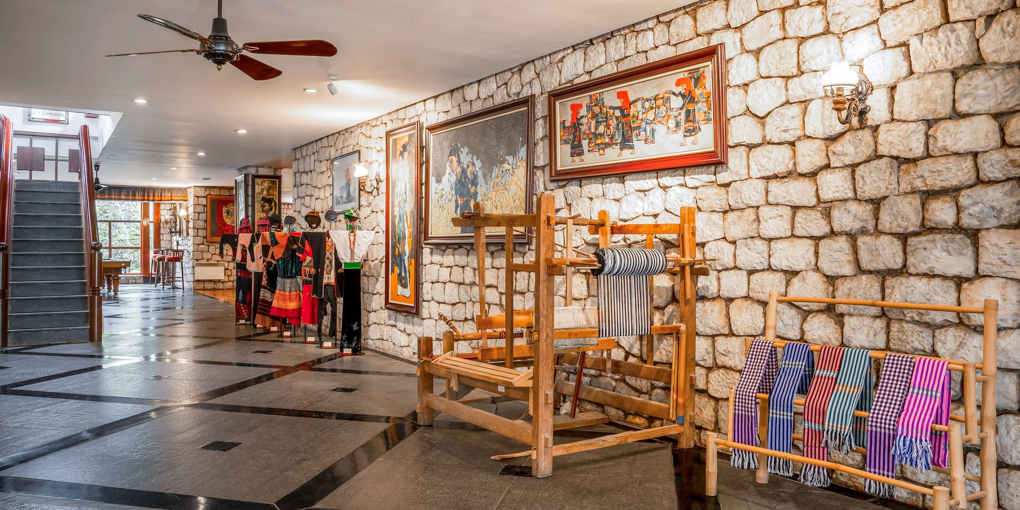 a room with a stone wall and a ceiling fan