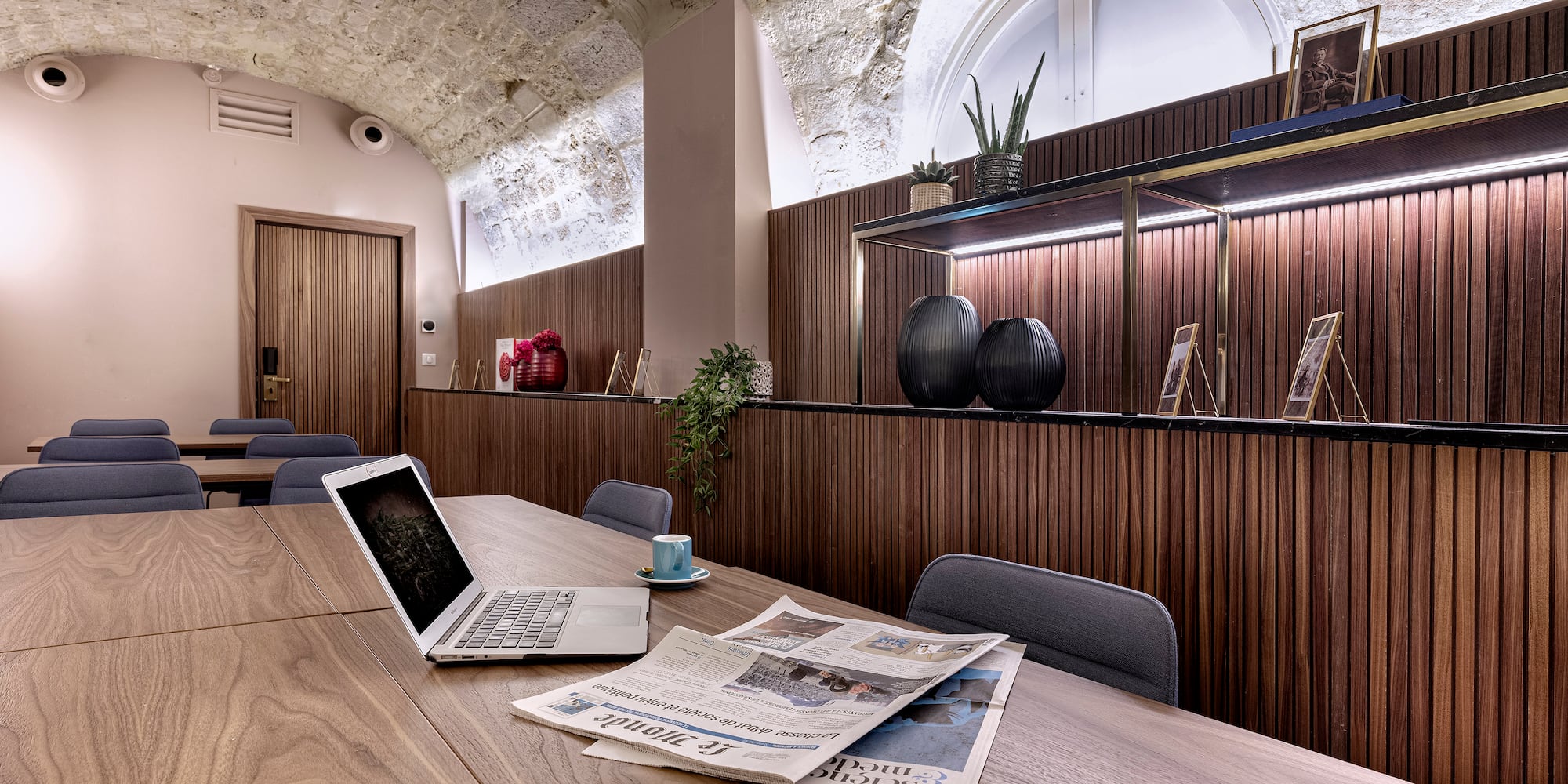 a room with a laptop and newspaper on a table