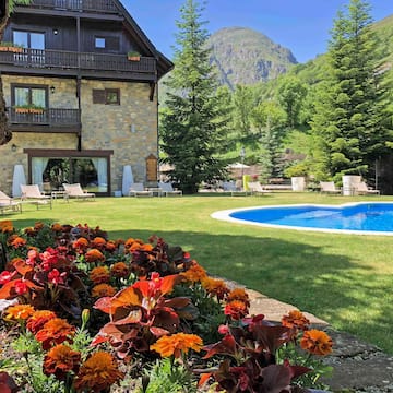 a pool in a house with flowers in front of it