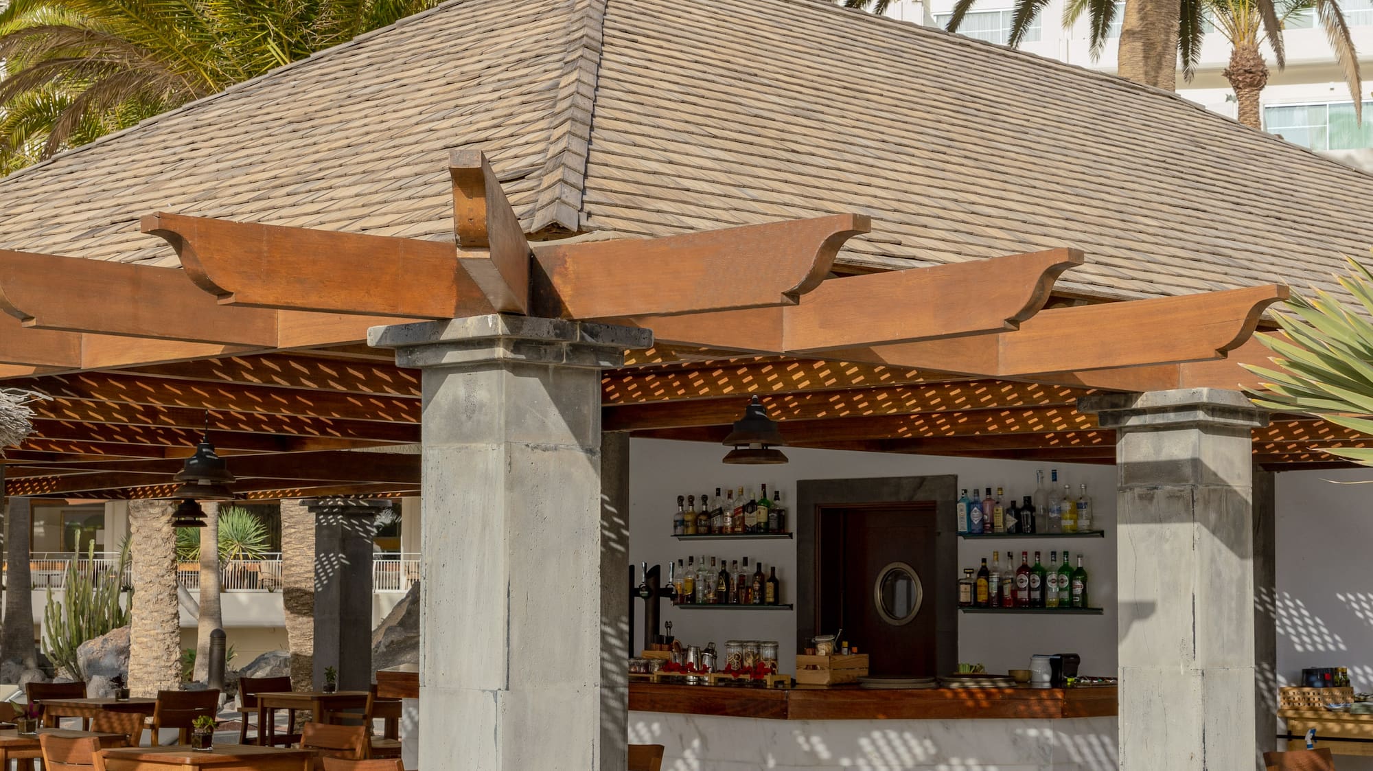 a restaurant with tables and chairs under a roof