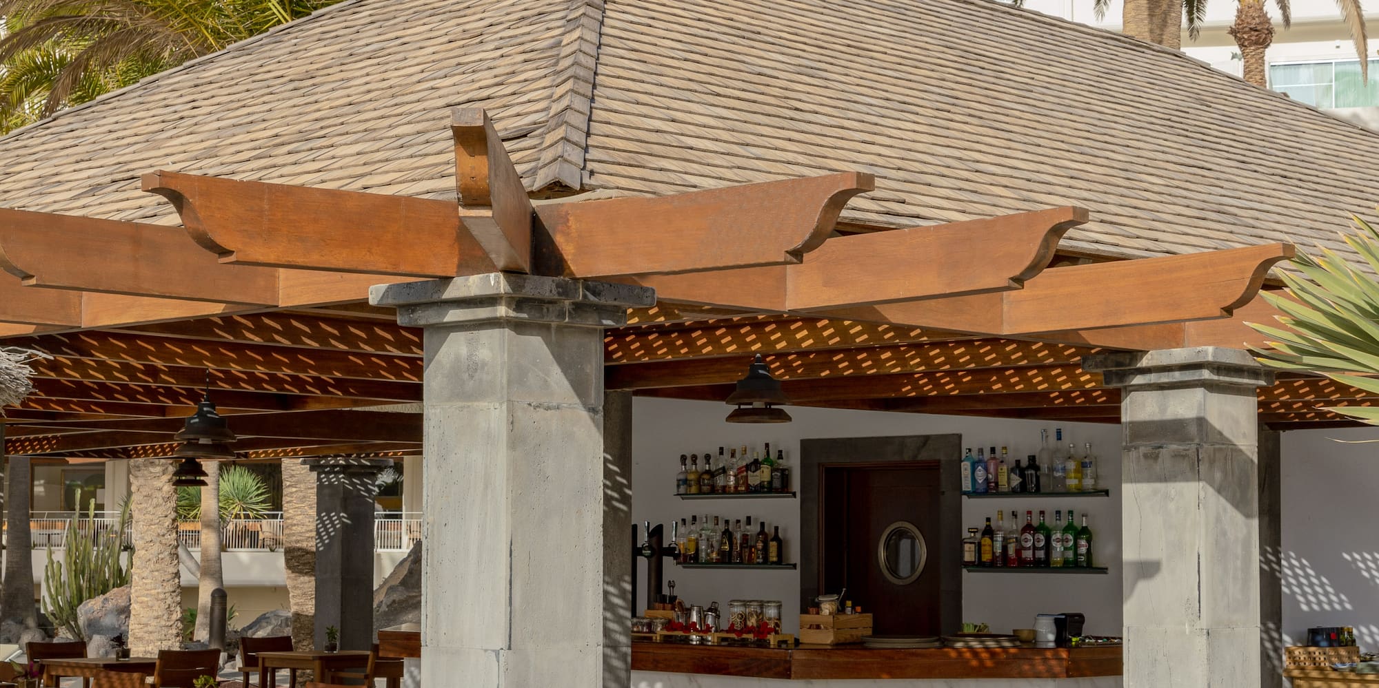 a restaurant with tables and chairs under a roof