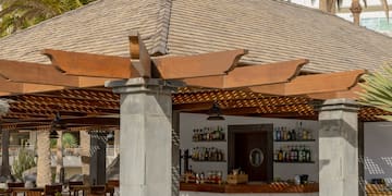 a restaurant with tables and chairs under a roof