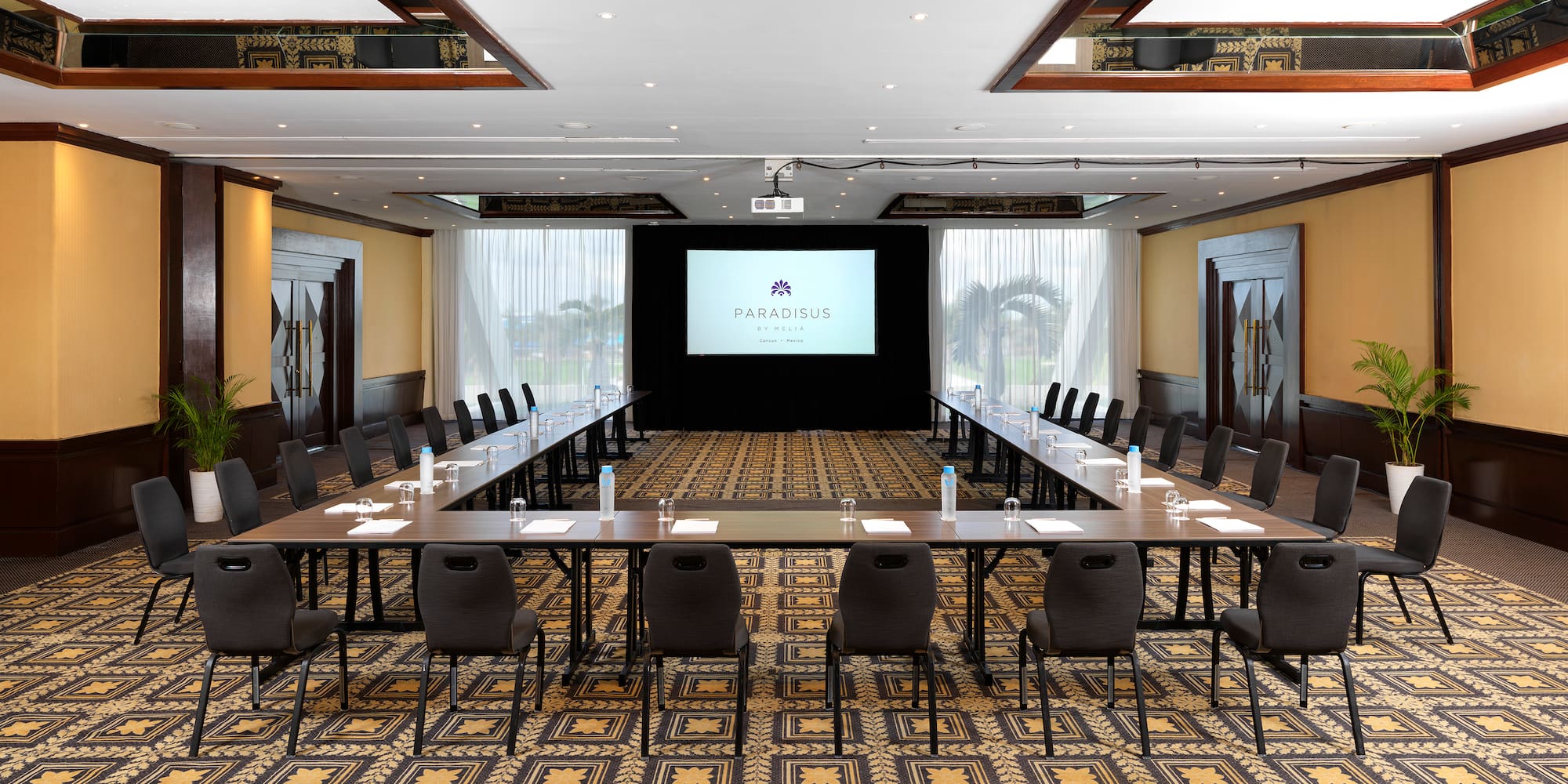 a room with a large screen and tables