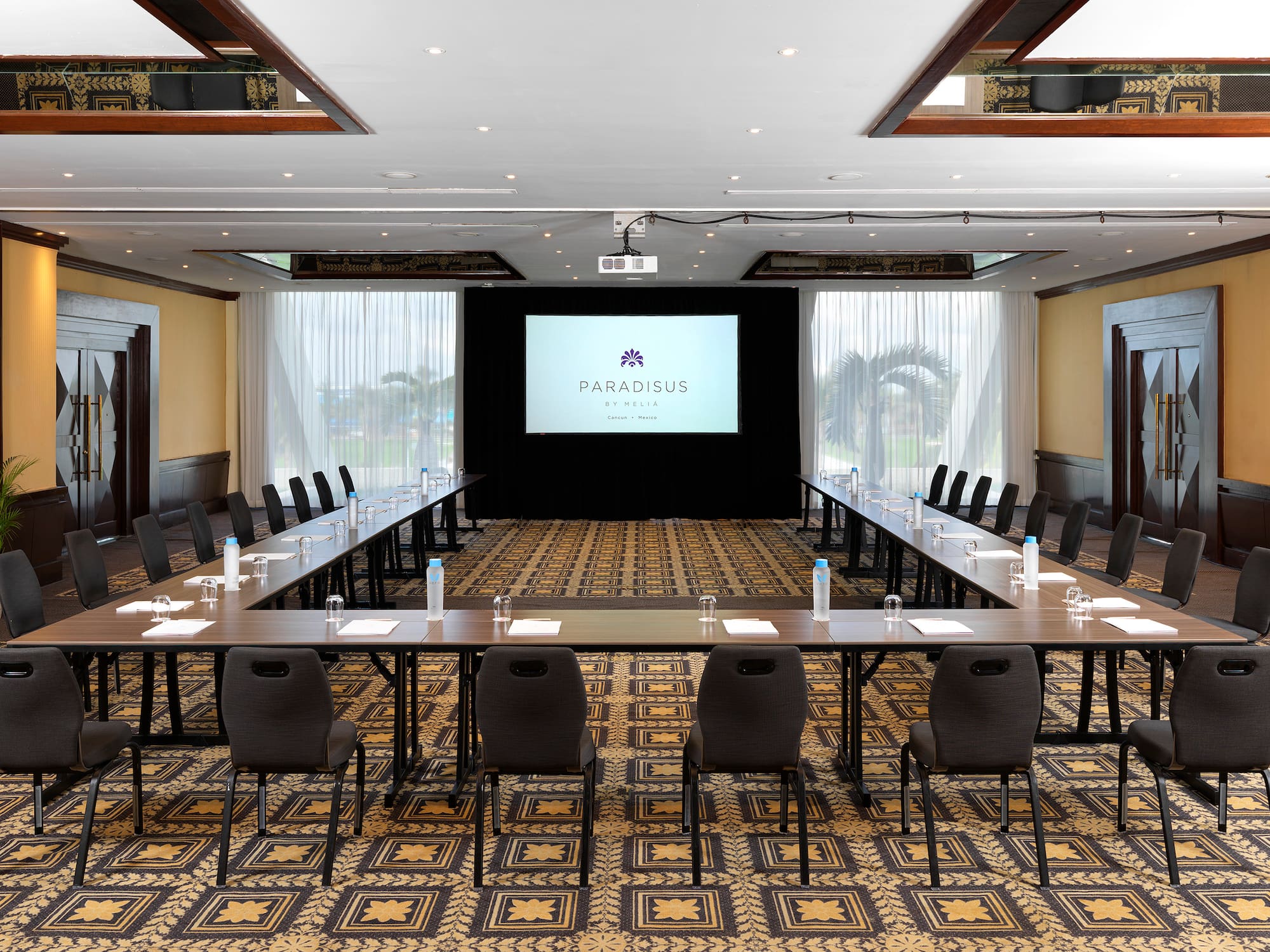 a room with a large screen and tables