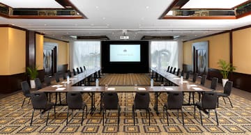 a room with a large screen and tables