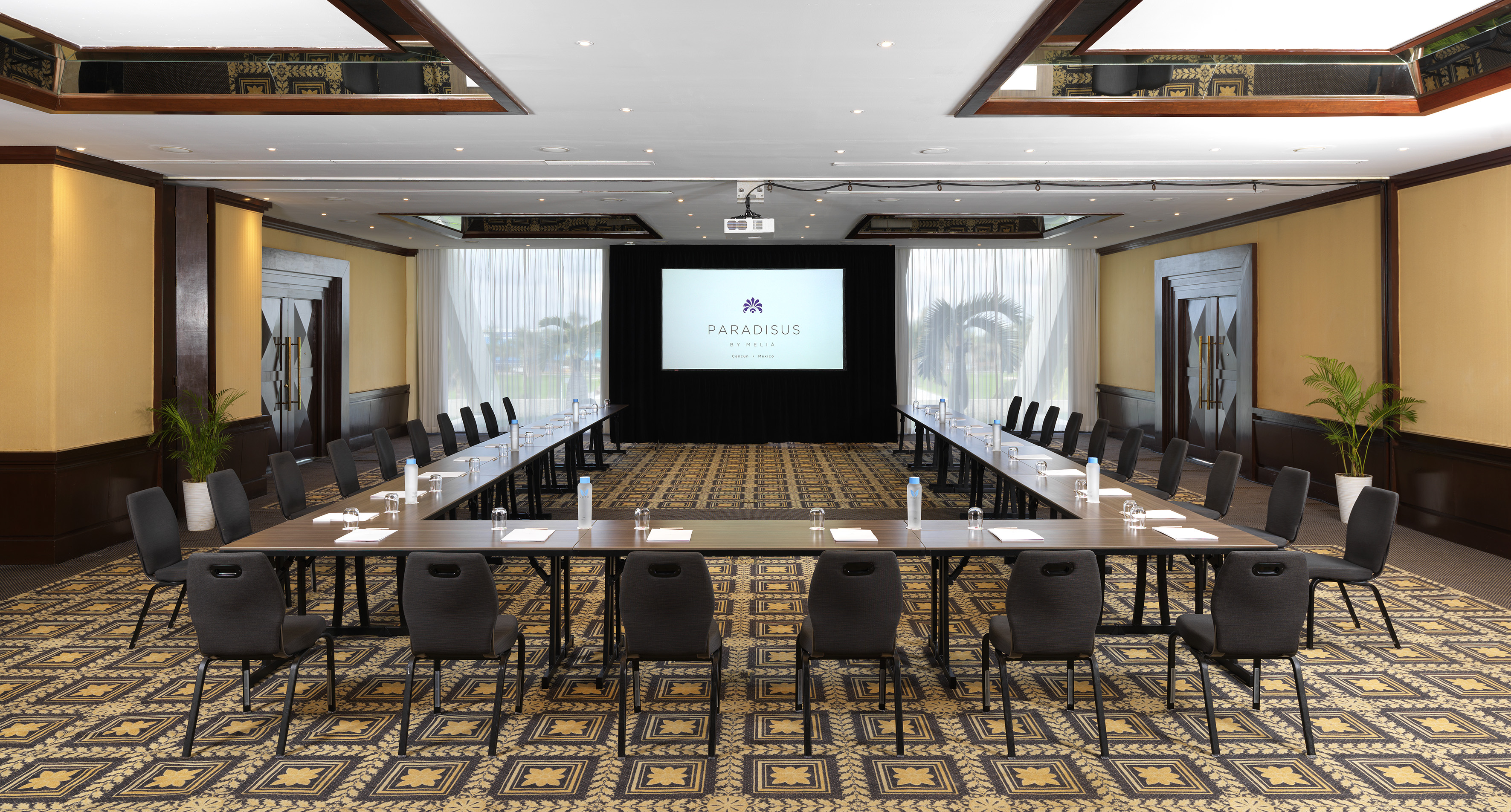 a room with a large screen and tables