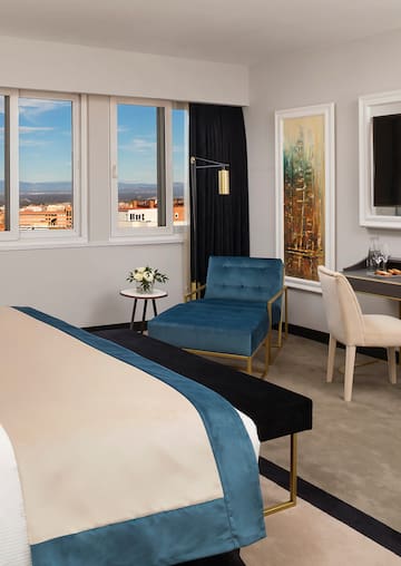 a bedroom with a bed and chairs