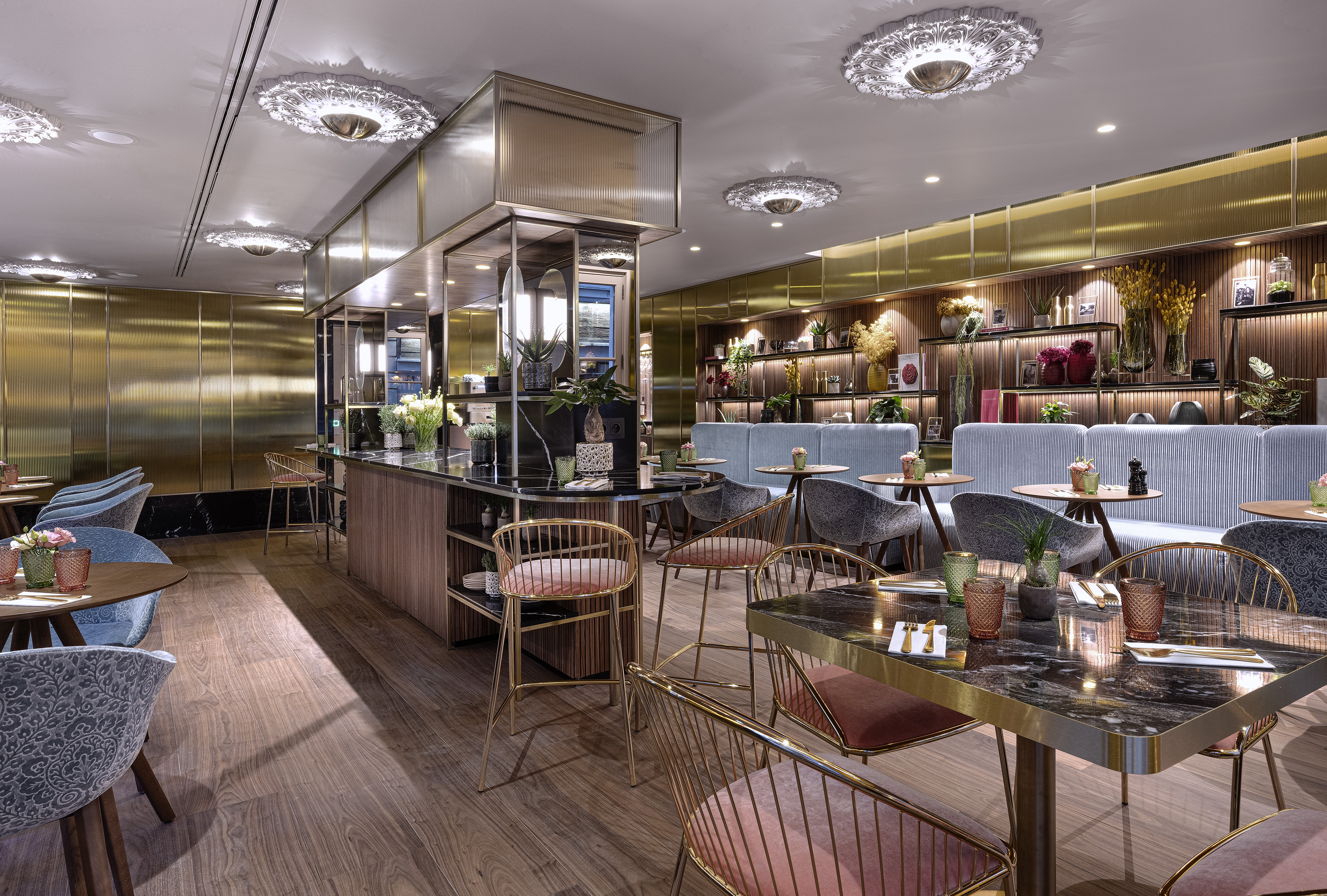 Elegant restaurant with gold accents, marble tables, and plush seating.