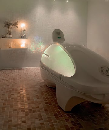 a white oval shaped object in a tiled room