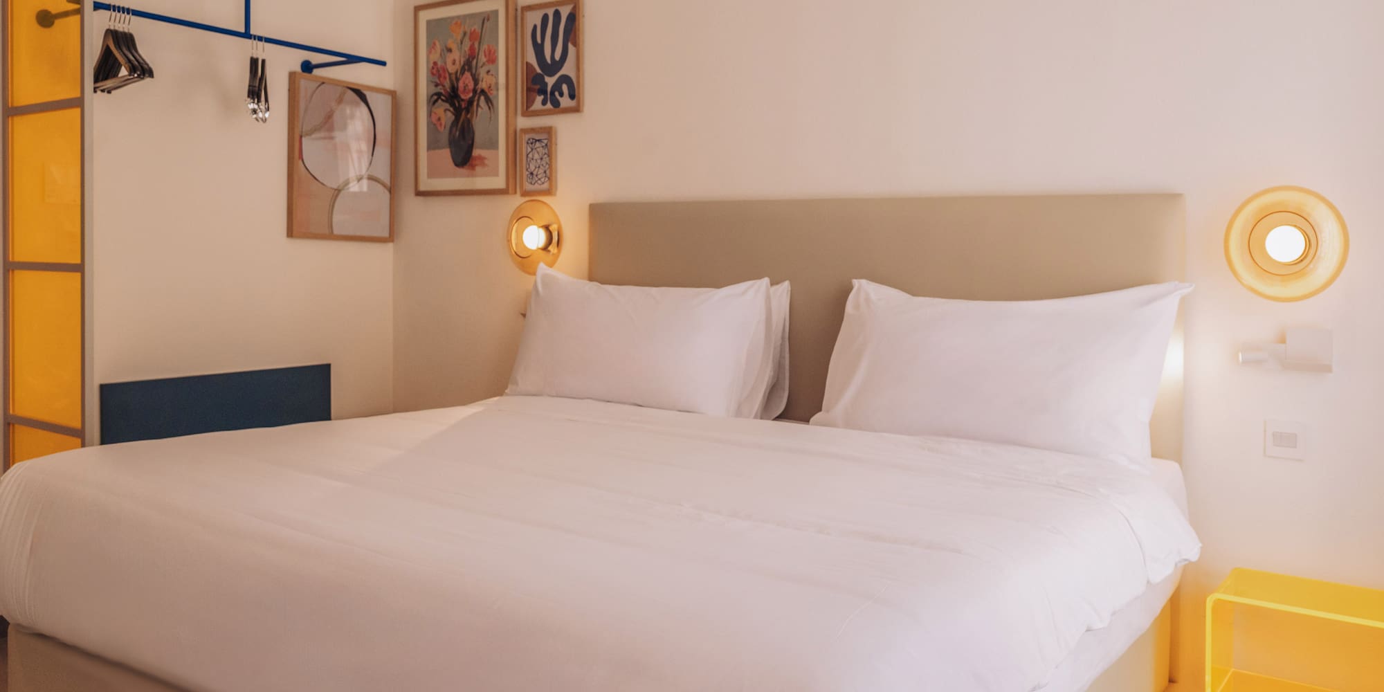 a bed with white sheets and pillows