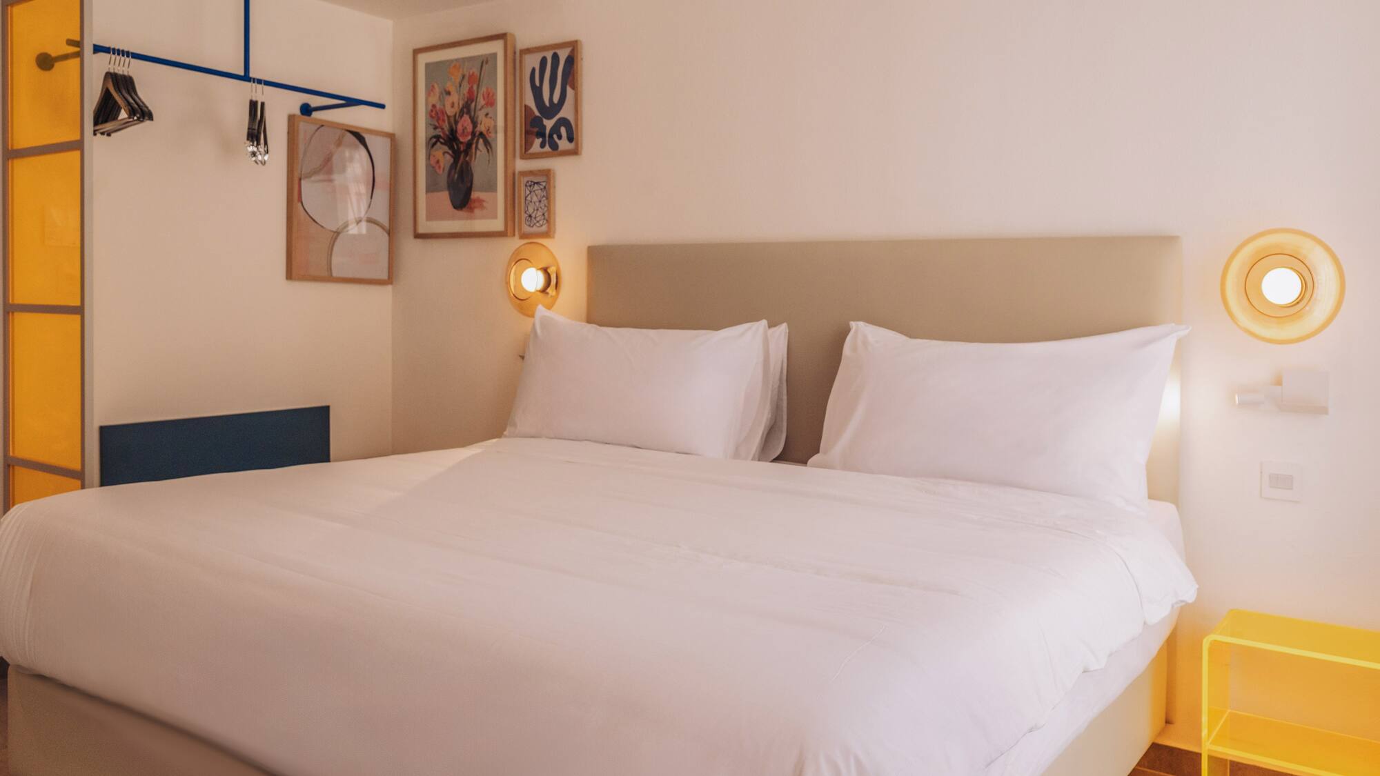 a bed with white sheets and pillows